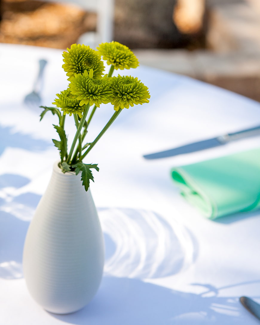 Green Chrysanthemums in White Vase on Outdoor Table