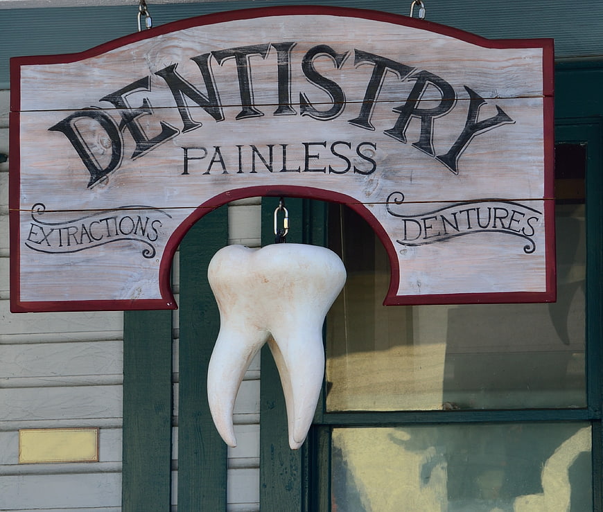 Vintage wooden dentistry sign with hanging tooth model