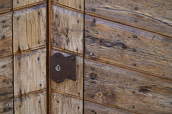 Close-up of weathered wooden door with vintage lock