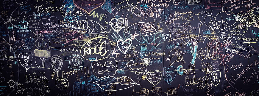 Colorful chalk graffiti on a dark blackboard wall