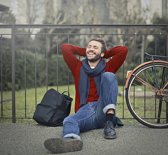 Happy man relaxing with bicycle in park