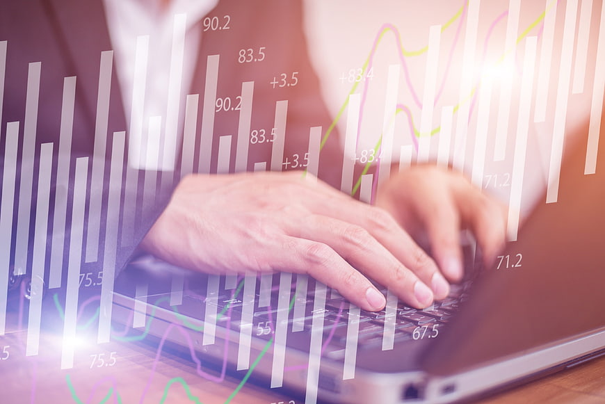 Businesswoman Typing on Laptop with Financial Graph Overlay