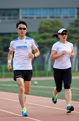 Man and Woman Running on Outdoor Track
