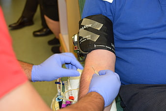 Close-up of blood donation procedure with medical gloves