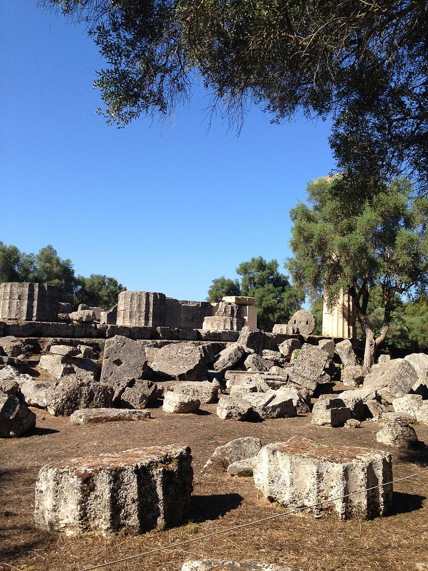 Ancient Greek Ruins Under Blue Sky with Olive Trees