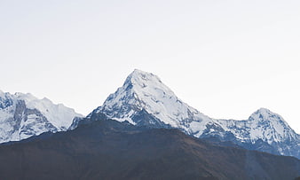 Snow-capped mountain peak with dark foreground hills