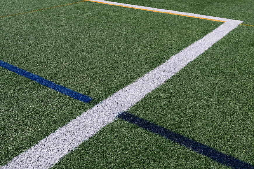 Close-up of artificial turf field with white and blue lines