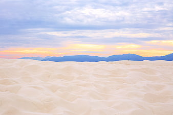 Vast White Sand Dunes at Sunset with Distant Mountains