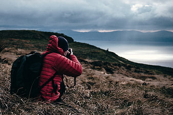 Photographer in Red Jacket Taking Pictures on Mountain Ridge