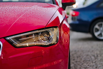 Close-up of a red Audi headlight with water droplets