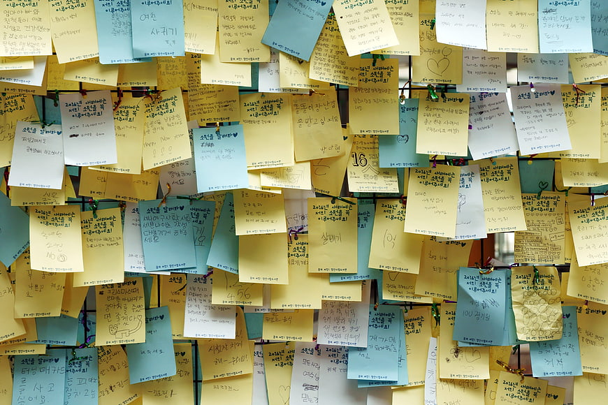 Wall of handwritten sticky notes with Korean text and messages