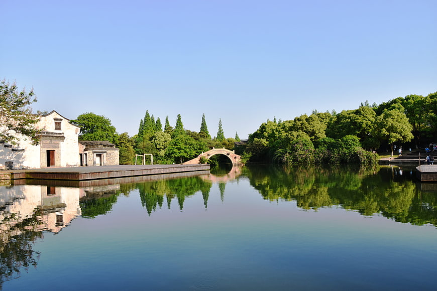 Traditional Chinese Architecture and Stone Bridge Over Calm Water