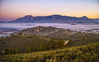 Misty mountain landscape at sunrise with rolling hills