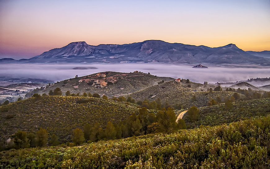 Misty mountain landscape at sunrise with rolling hills