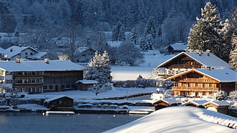 Snow-covered Swiss chalets by a lake in winter