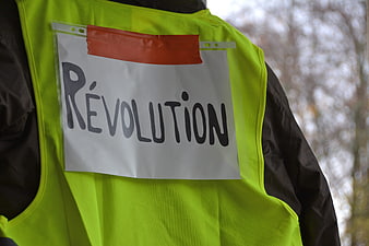 Close-up of a yellow vest with a handwritten revolution sign