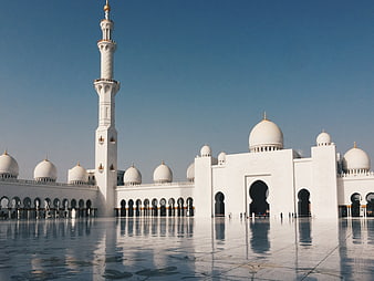 White Mosque with Minaret and Domes Reflecting in Courtyard