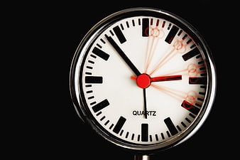 Close-up of analog quartz clock face on black background