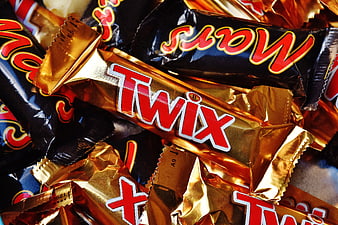 Close-up of Twix and Mars chocolate bars in gold and black wrappers