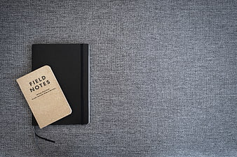 Minimalist black notebook and field notes on gray textured background