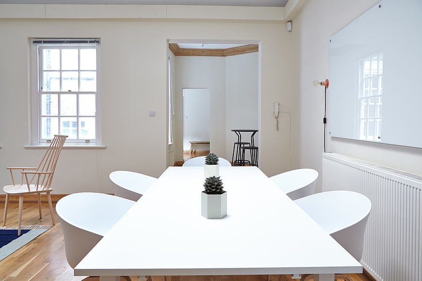 Minimalist white meeting room with modern table and chairs