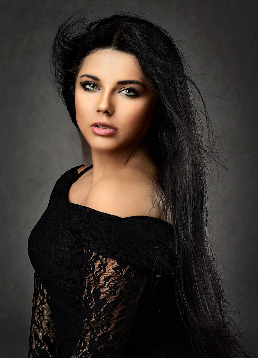 Portrait of a woman with long black hair and green eyes