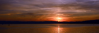 Panoramic Lake Sunset With Distant Mountains And Calm Water