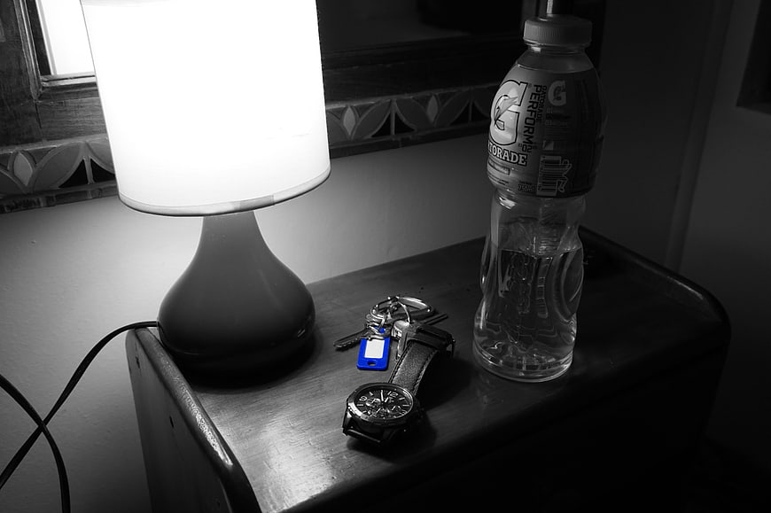 Black and white still life of lamp, watch, keys, and Gatorade bottle