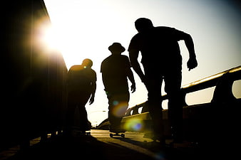 Silhouettes of Skateboarders Riding at Sunset