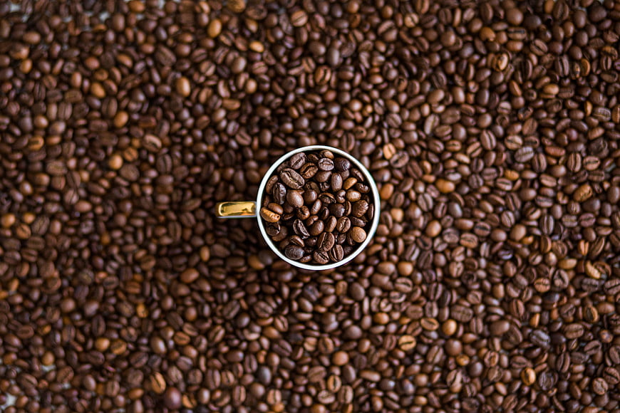 Top down view of coffee beans in a white cup