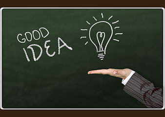 Hand holding lightbulb drawing on chalkboard with good idea text