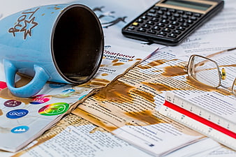 Spilled coffee on business documents and calculator