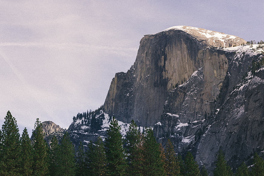 Snow-Capped Granite Mountain Peak with Pine Forest
