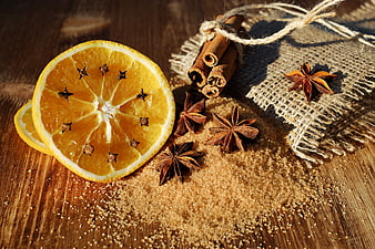 Dried orange slices with cinnamon, star anise, and brown sugar on wood