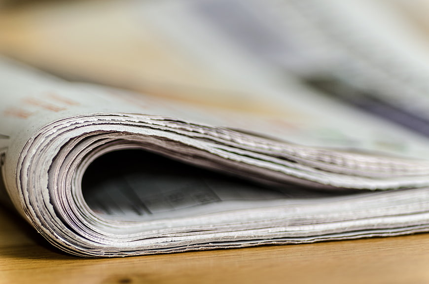 Close-up of folded newspaper pages on wooden surface