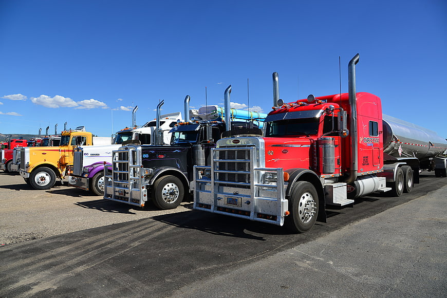Row of colorful semi-trucks parked in a sunny lot