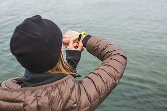 Woman Checking Yellow Fitness Tracker by Water