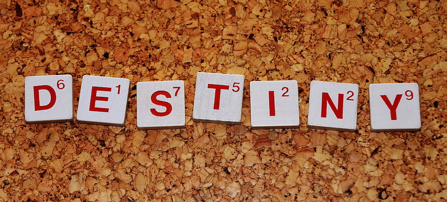 Scrabble tiles spelling DESTINY on a textured cork background