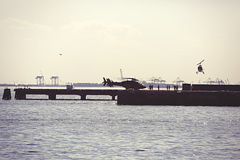 Helicopters Landing on Harbor Dock with Cranes
