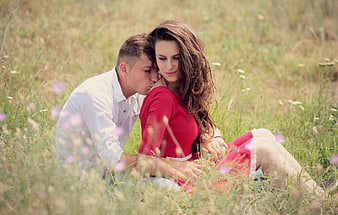 Romantic couple kissing in a field of wildflowers