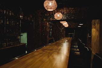 Dimly lit rustic bar interior with wooden counter and hanging lights