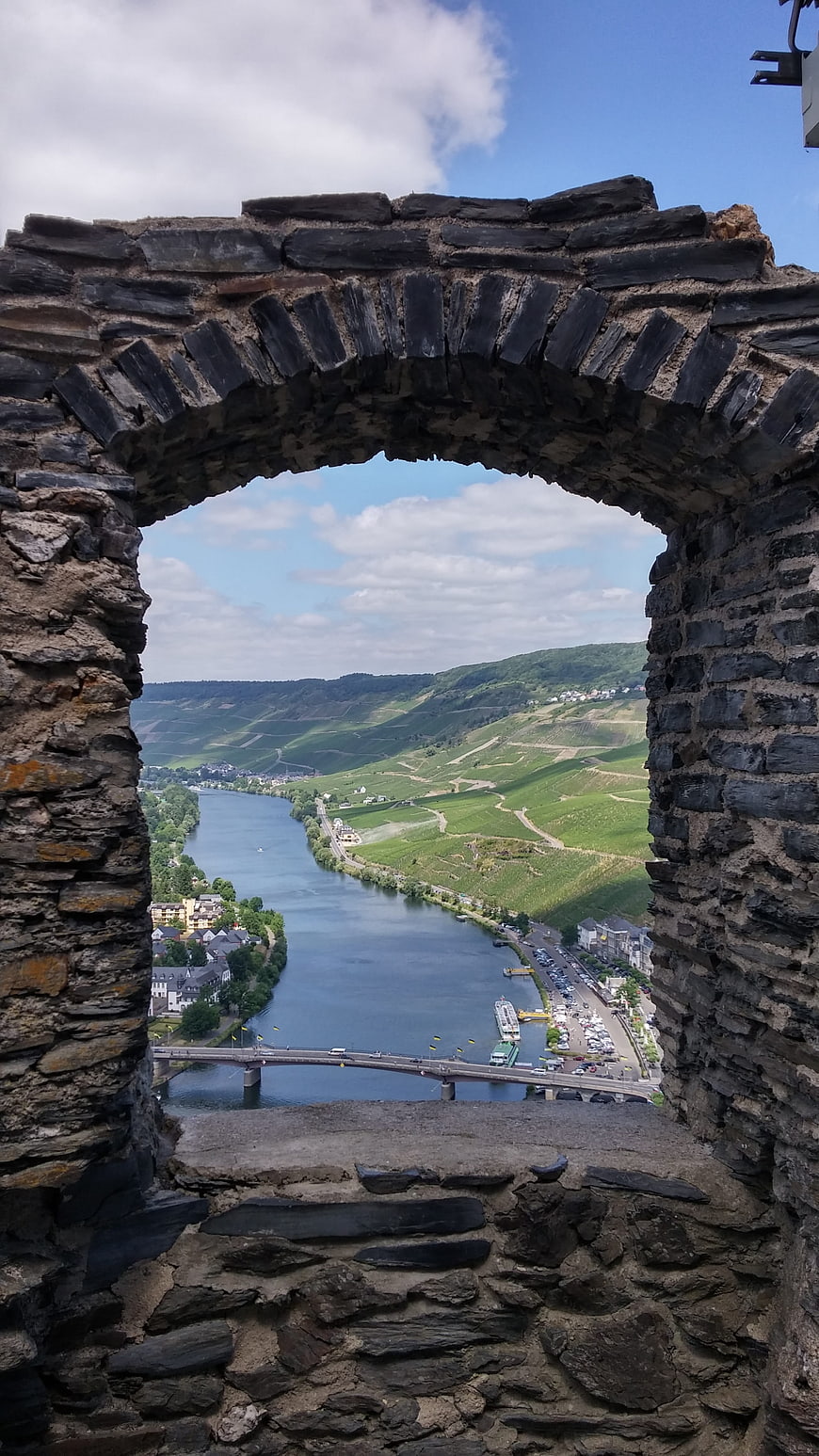Stone archway view of river valley and vineyards