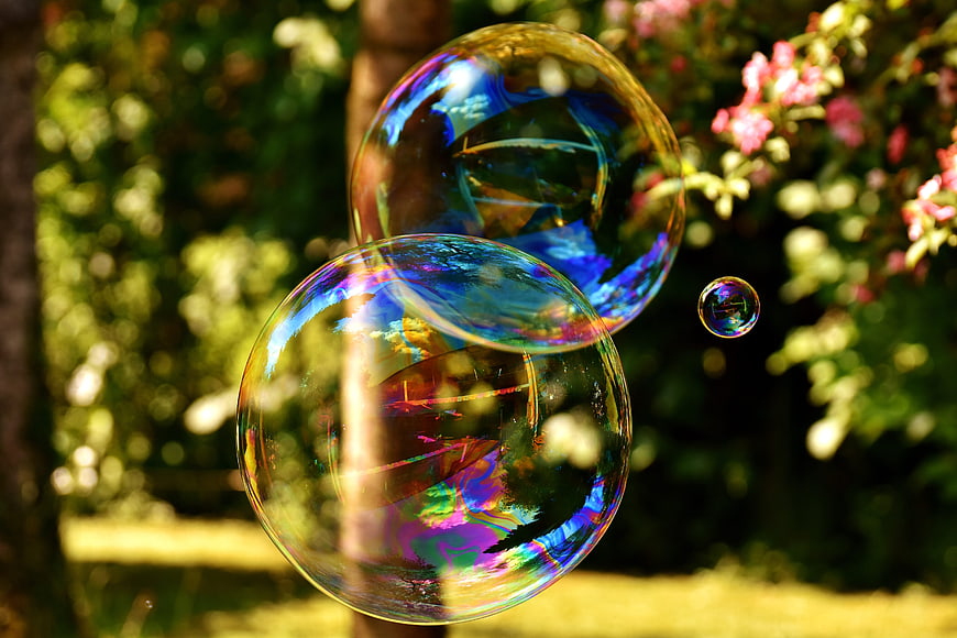 Iridescent soap bubbles floating in a sunny garden