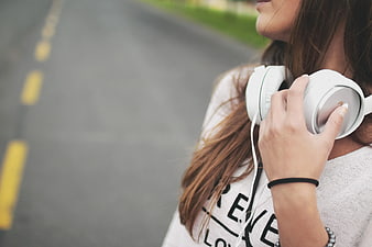 Woman with White Headphones on Road