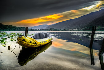 Yellow Inflatable Boat on Lake at Sunset with Mountain Reflection