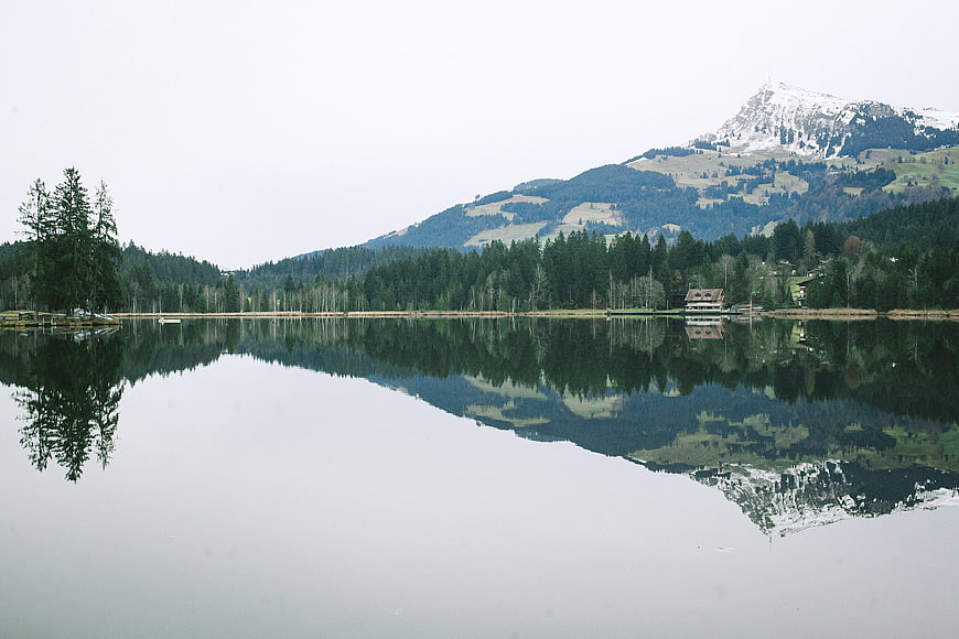Serene Alpine Lake with Mountain Reflection and Forest