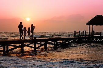 Family Silhouette on Wooden Pier at Sunset