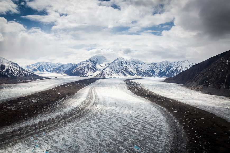 Aerial View of Snow-Covered Glacier Valley with Mountains
