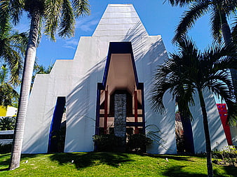 Modern white hotel architecture with blue accents and palm trees