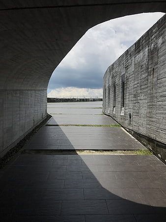 Modern concrete architecture with dramatic shadows and cloudy sky